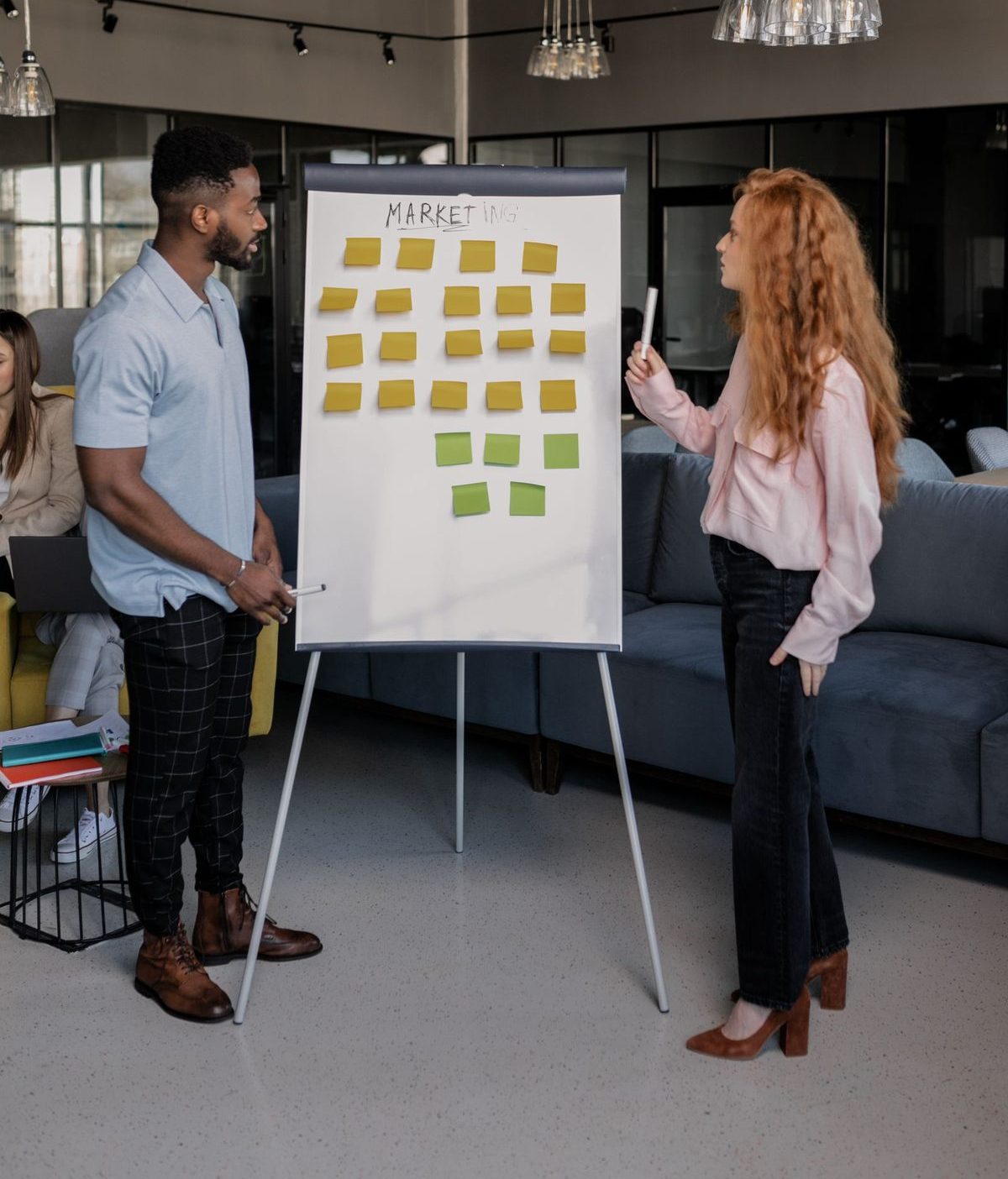 Twee collega's bespreken een aanpak met sticky notes voor een whiteboard